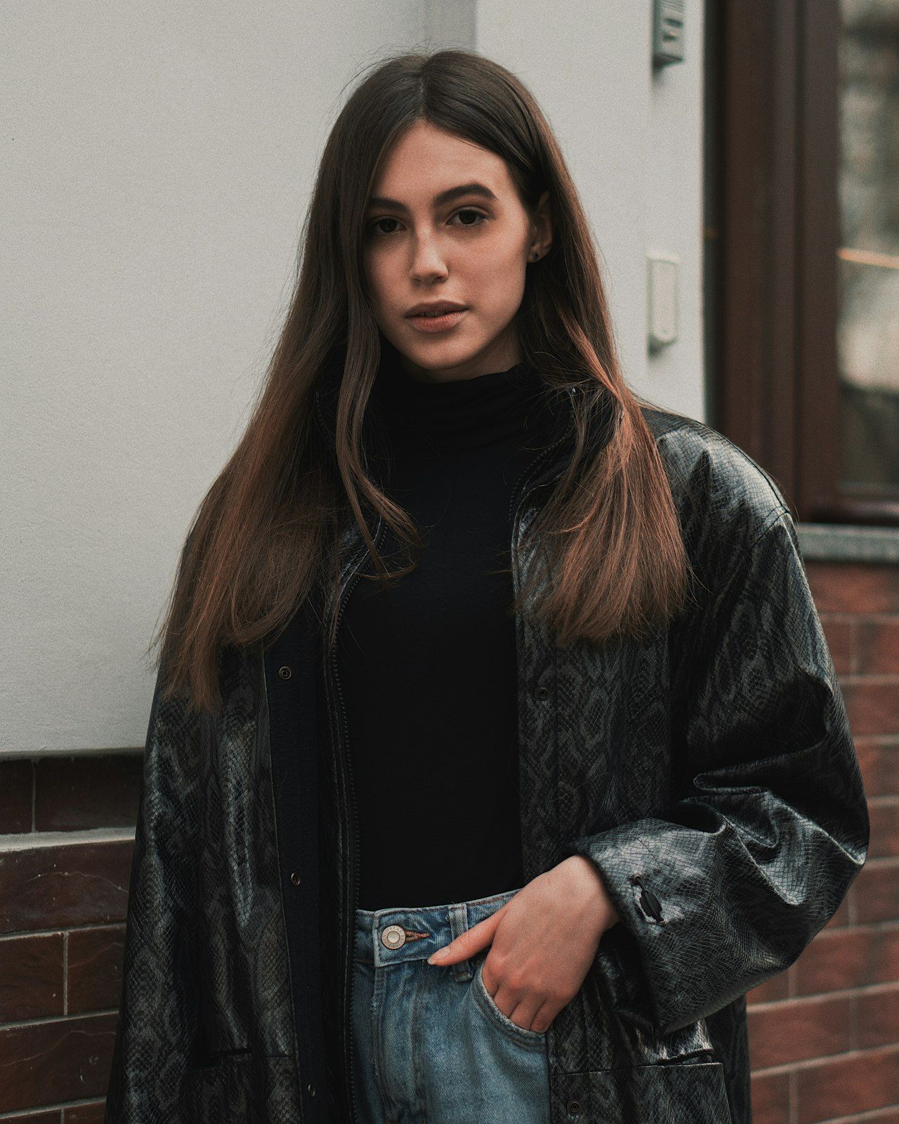 Full-length tailoring look photographed against a painted backdrop.