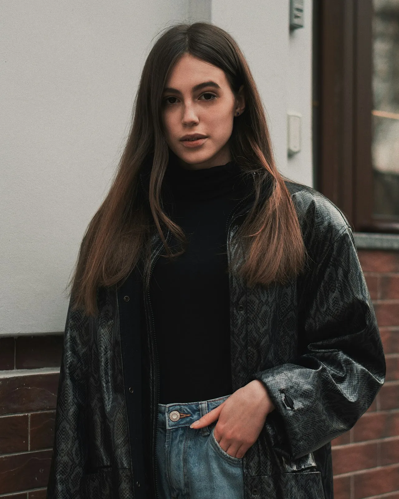 Full-length tailoring look photographed against a painted backdrop.