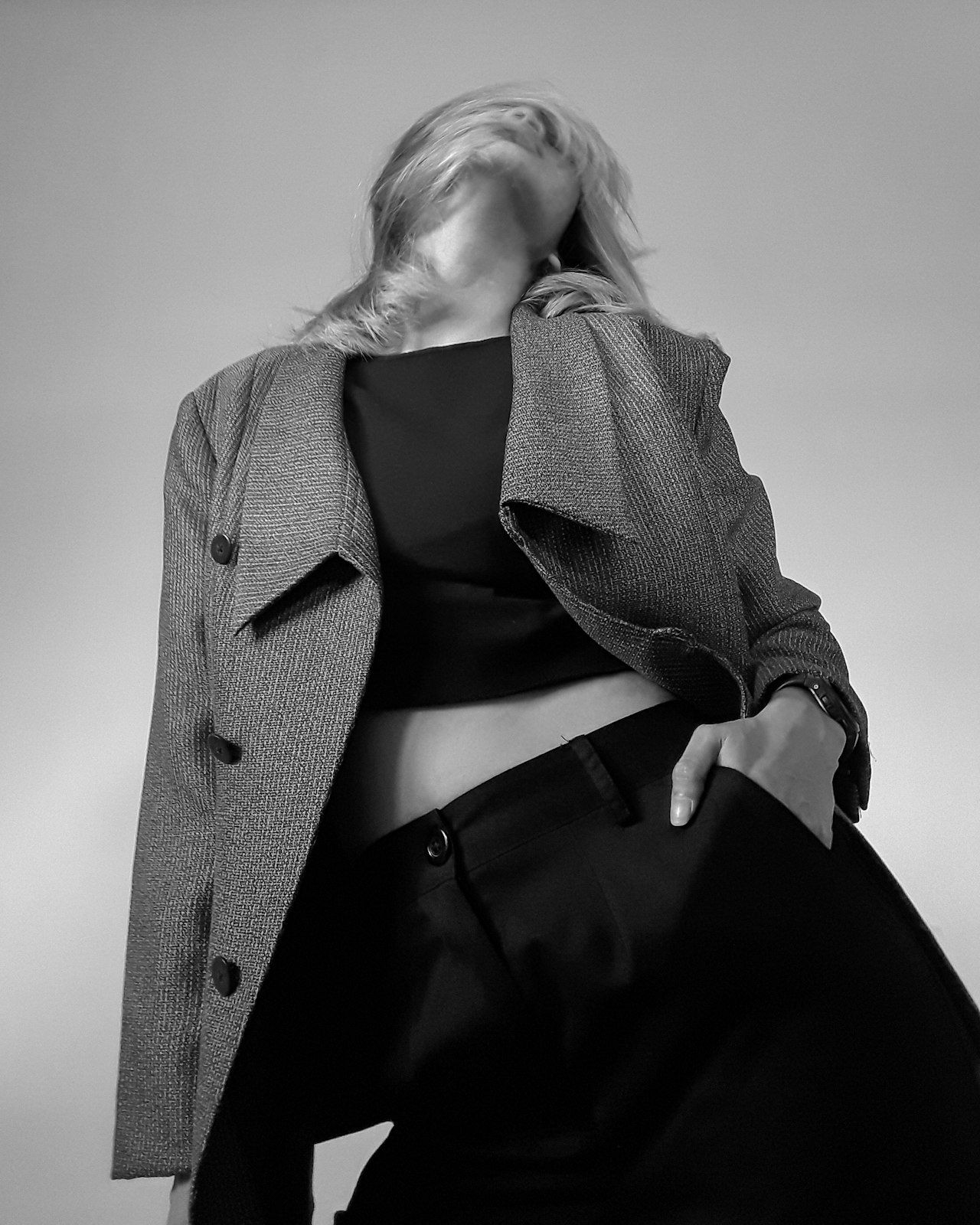 A black-and-white figure caught mid-motion in a tailored coat, face blurred.