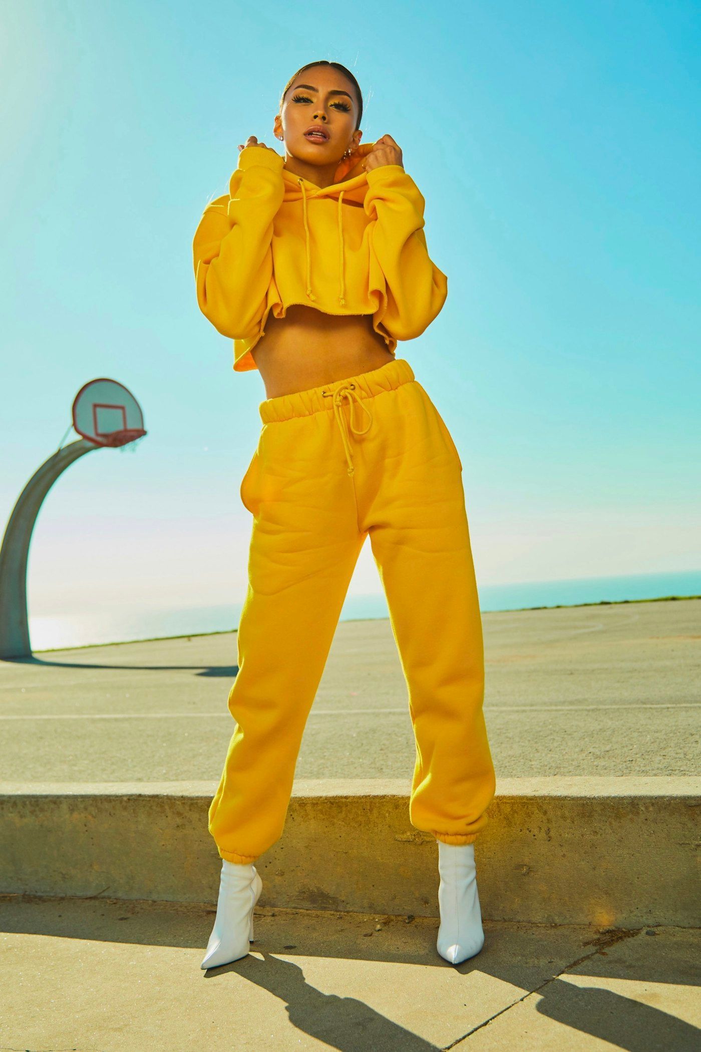 Caroline Levielle's work — a full-length fashion figure in a yellow set against open sky.