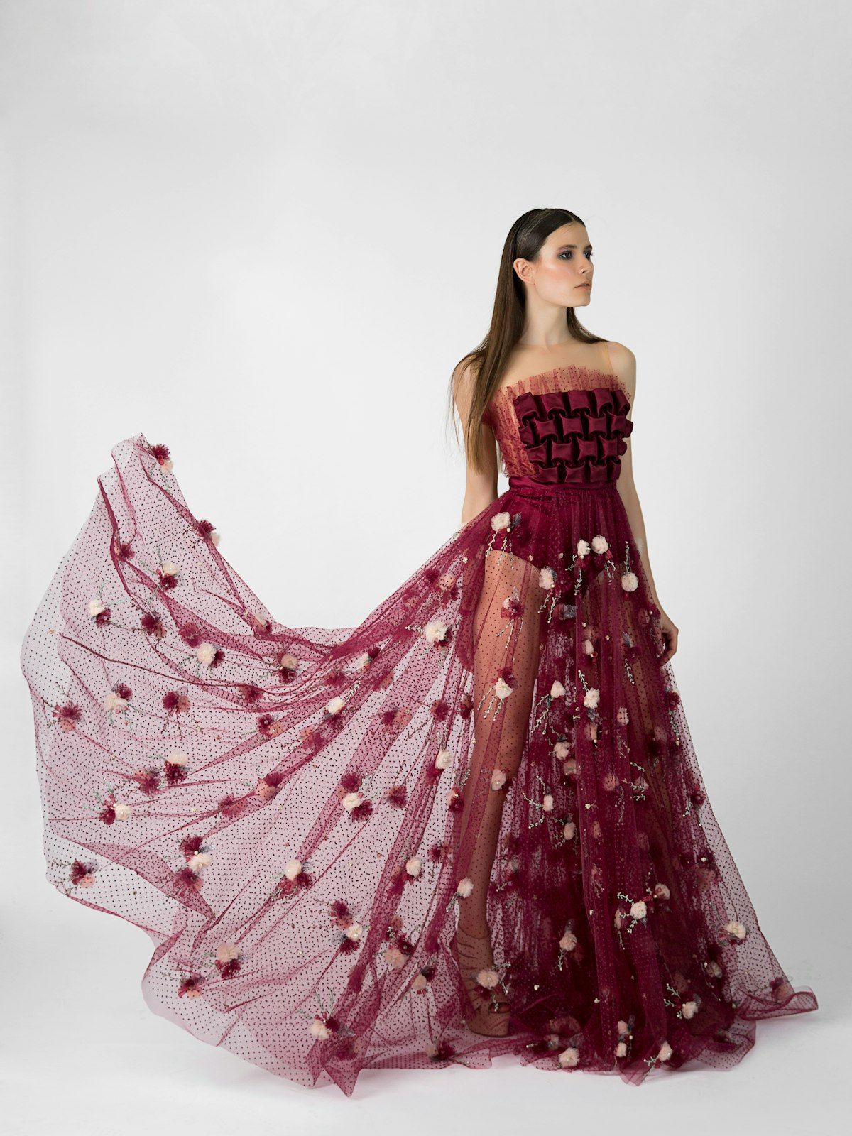 A couture gown editorial, burgundy tulle in studio light.